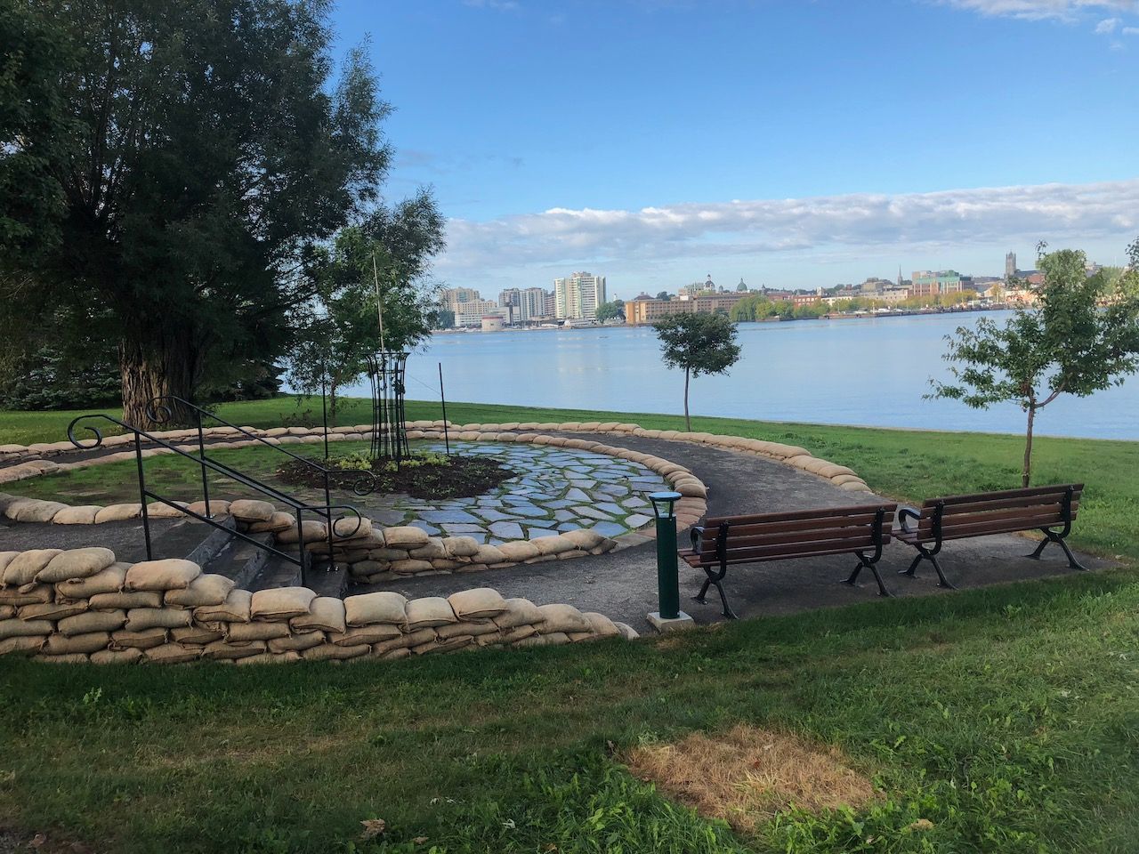 A park with a lake in the background and benches in the foreground