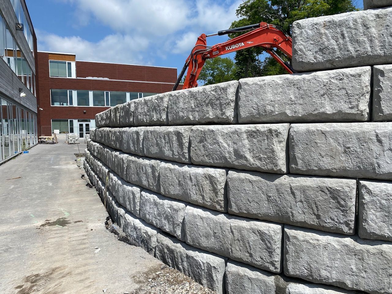 A large brick wall is being built in front of a building.