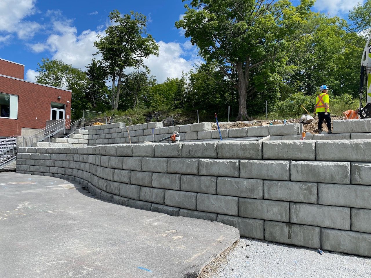 A large concrete wall is being built in front of a building.