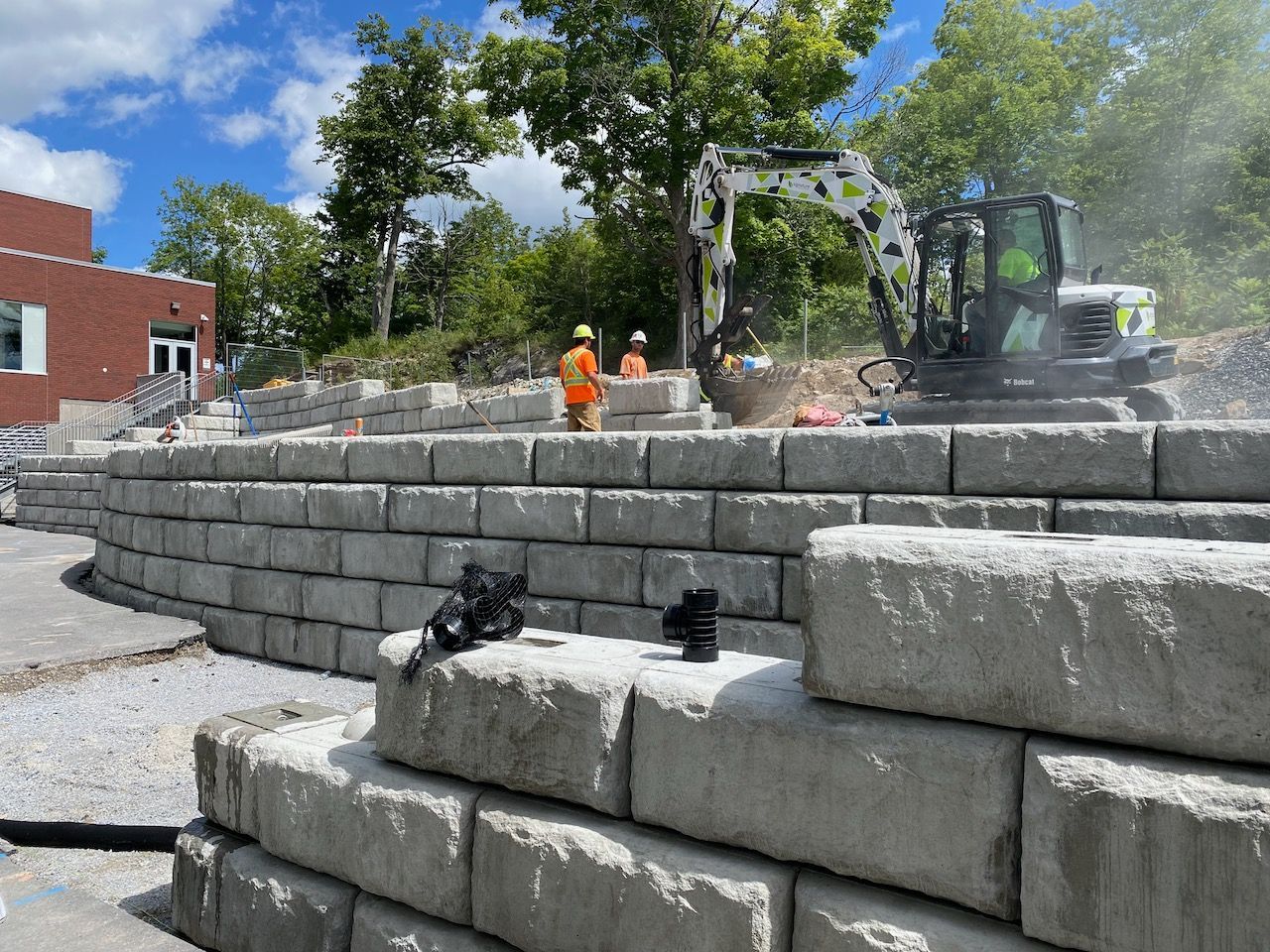 A group of construction workers are working on a retaining wall.