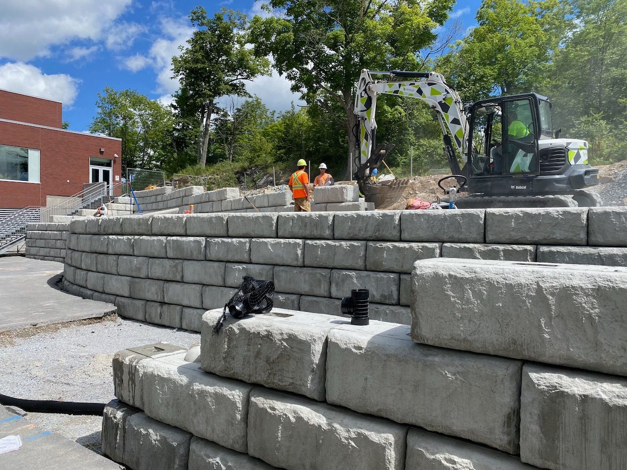 A group of construction workers are working on a concrete wall.