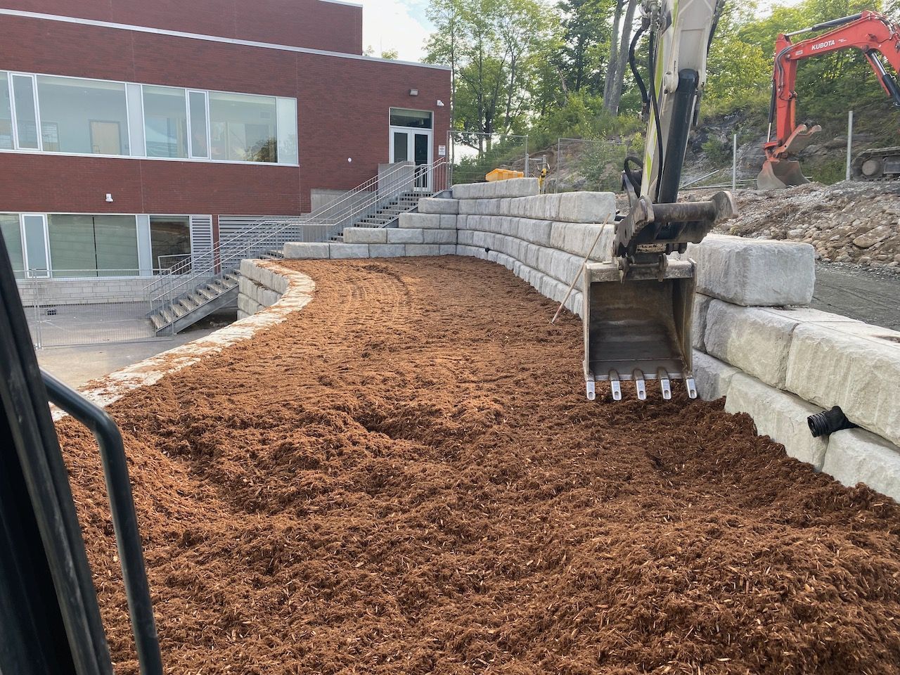 A bulldozer is moving dirt in front of a building.
