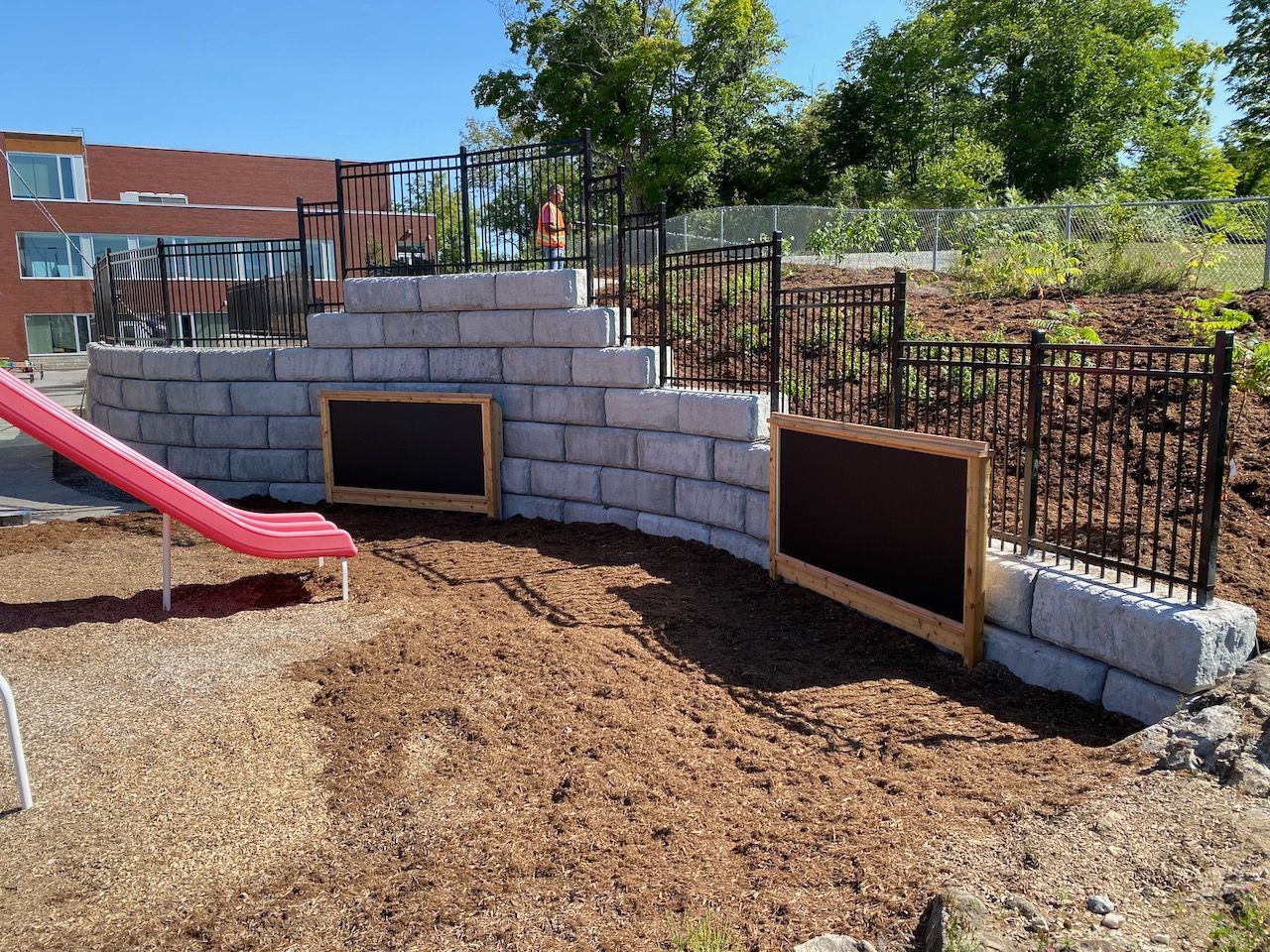 A playground with a slide and a chalkboard