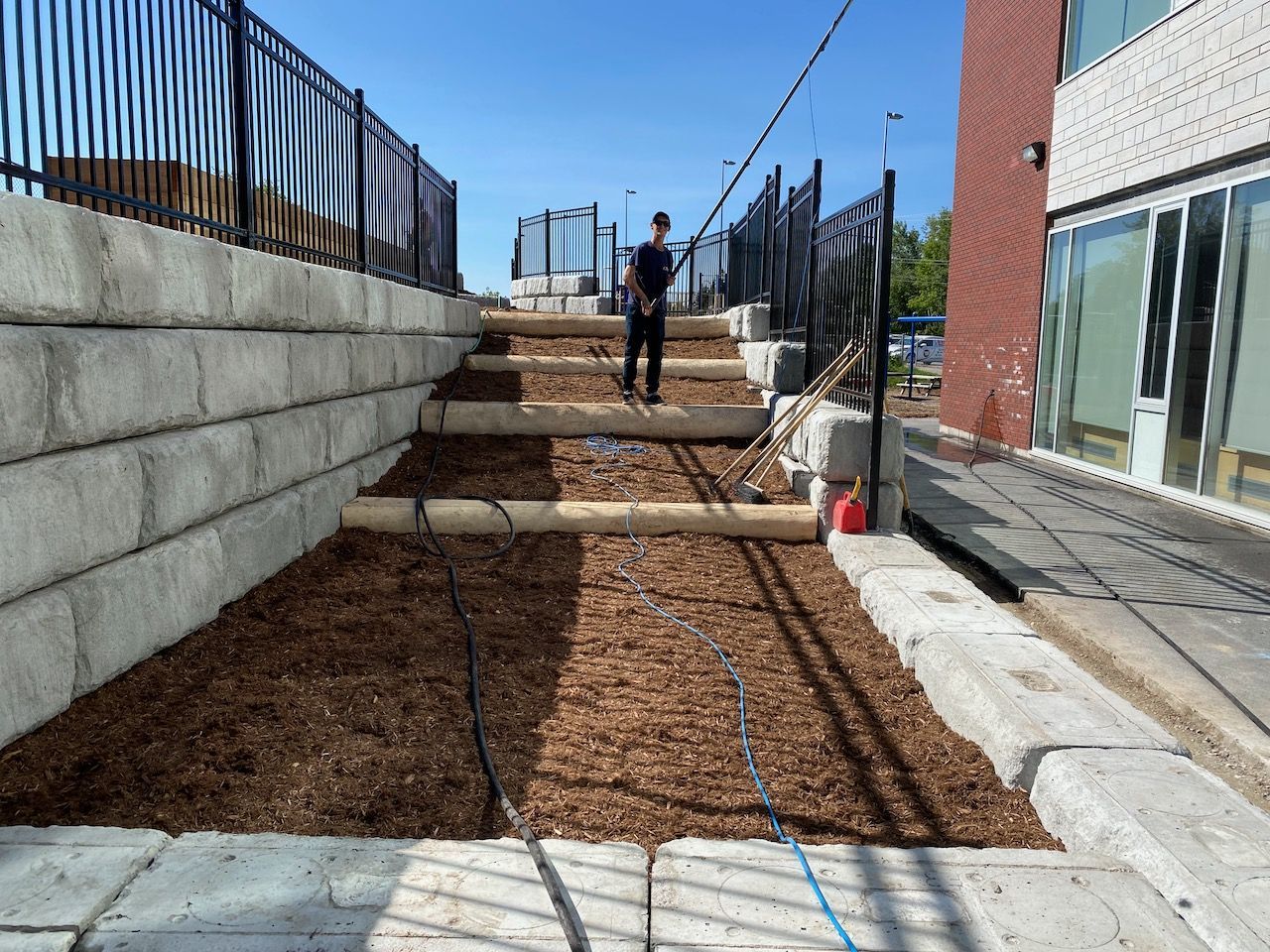 A man is standing in a yard next to a building.