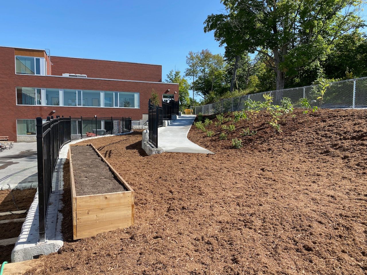A large brick building with a wooden planter in front of it.