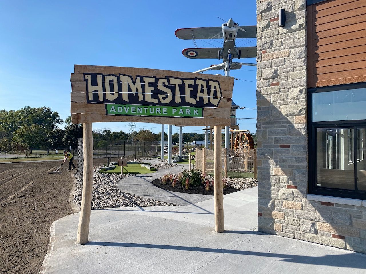 A wooden sign that says homestead adventure park on it