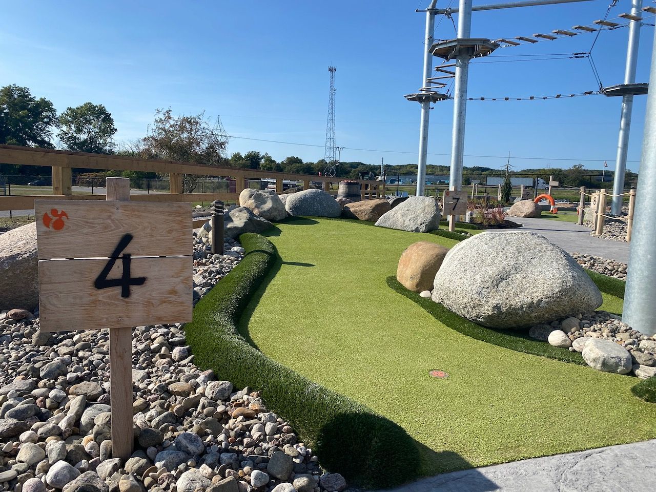 A wooden sign with the number four on it is on a golf course.