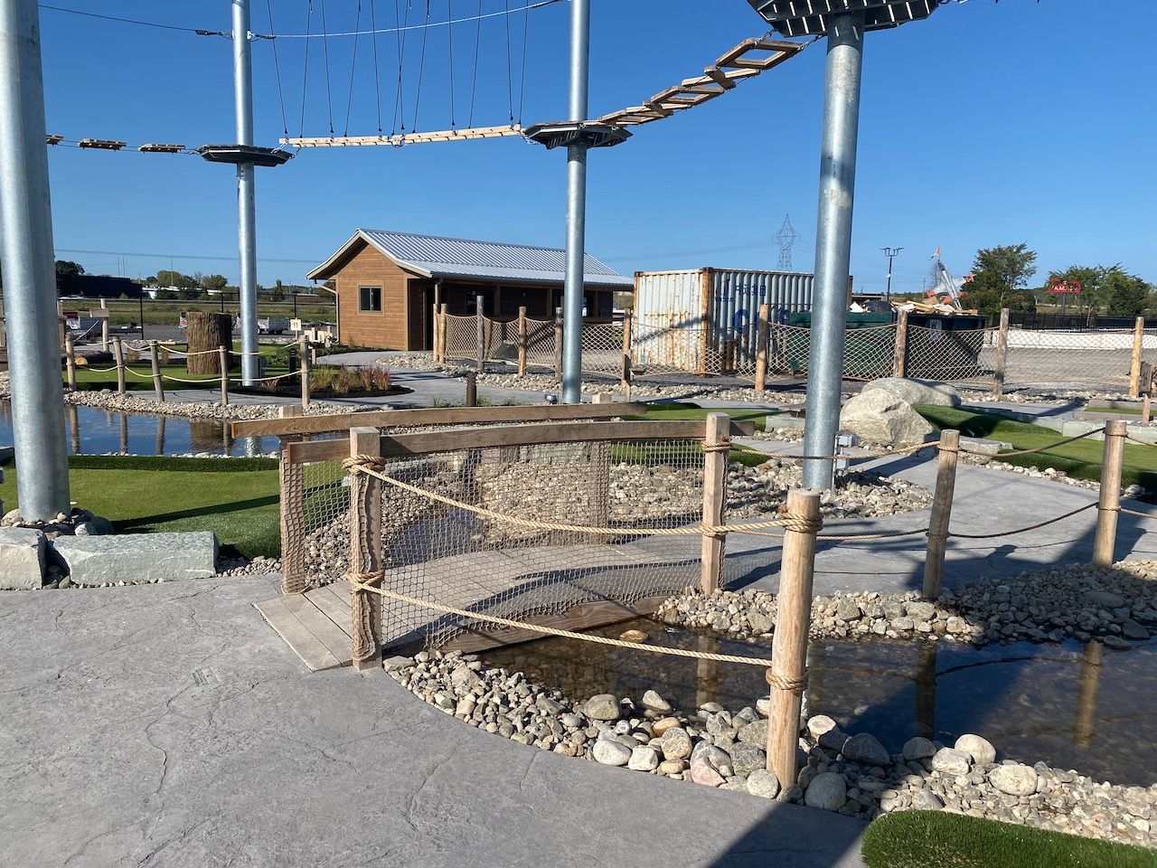 A ropes course in a park with a house in the background