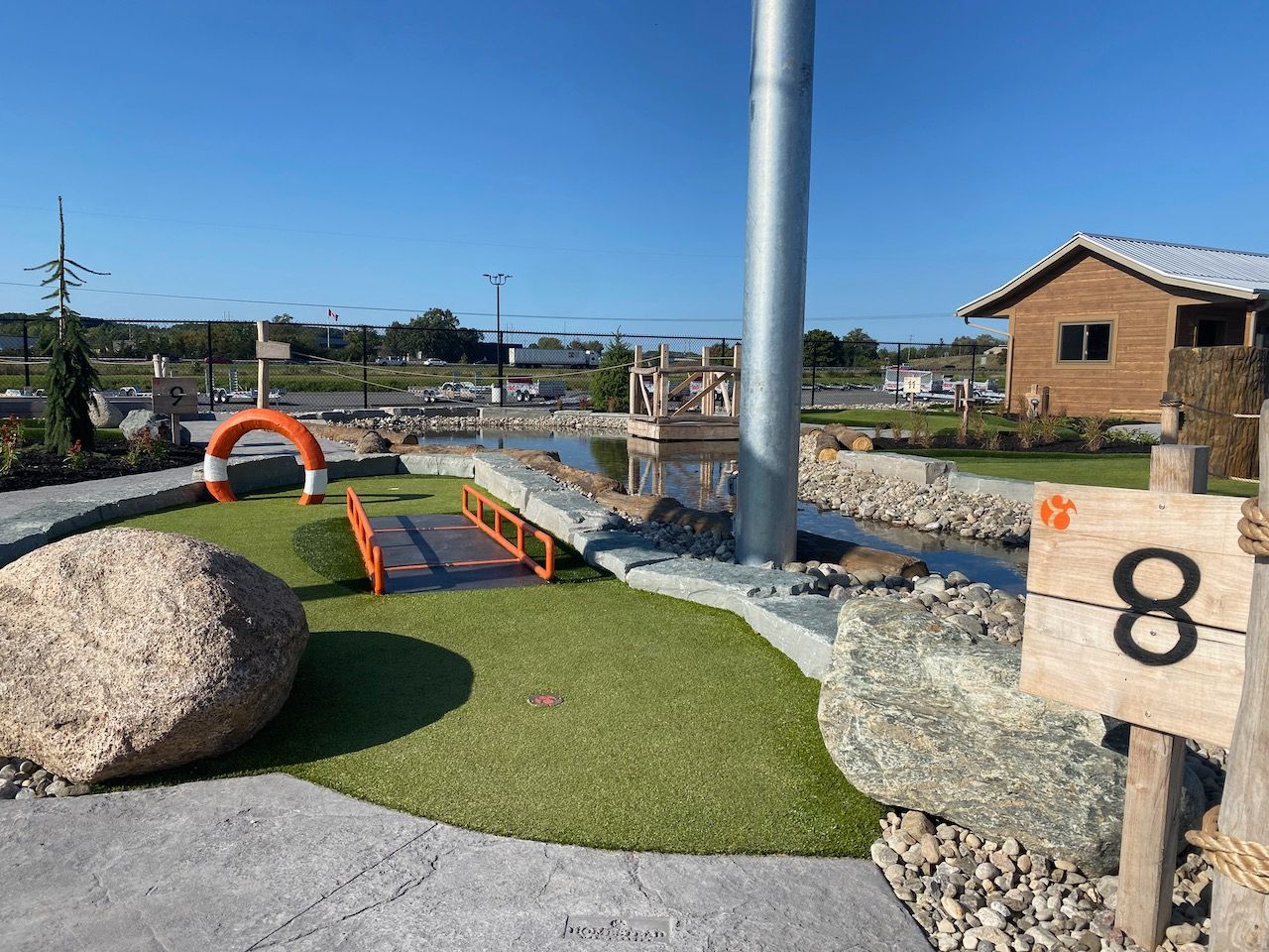 A small golf course with a wooden sign that says 8 on it.