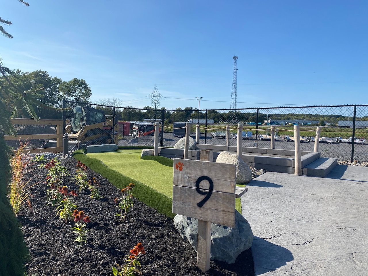 A wooden sign with the number 9 on it is in the middle of a garden.