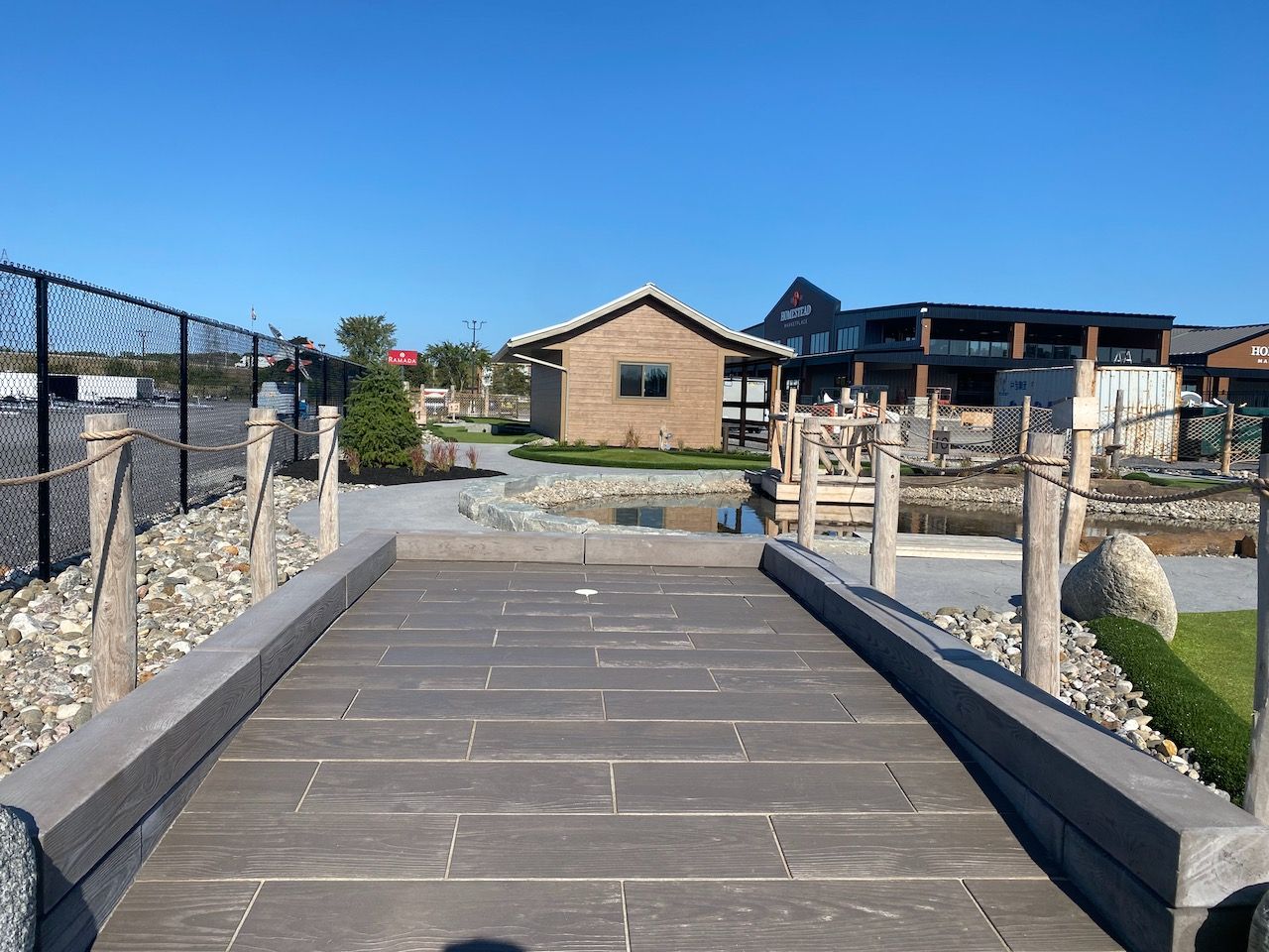 A bridge leading to a house with a blue sky in the background