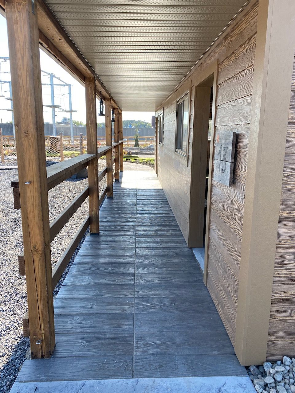 A long hallway between two buildings with a wooden railing