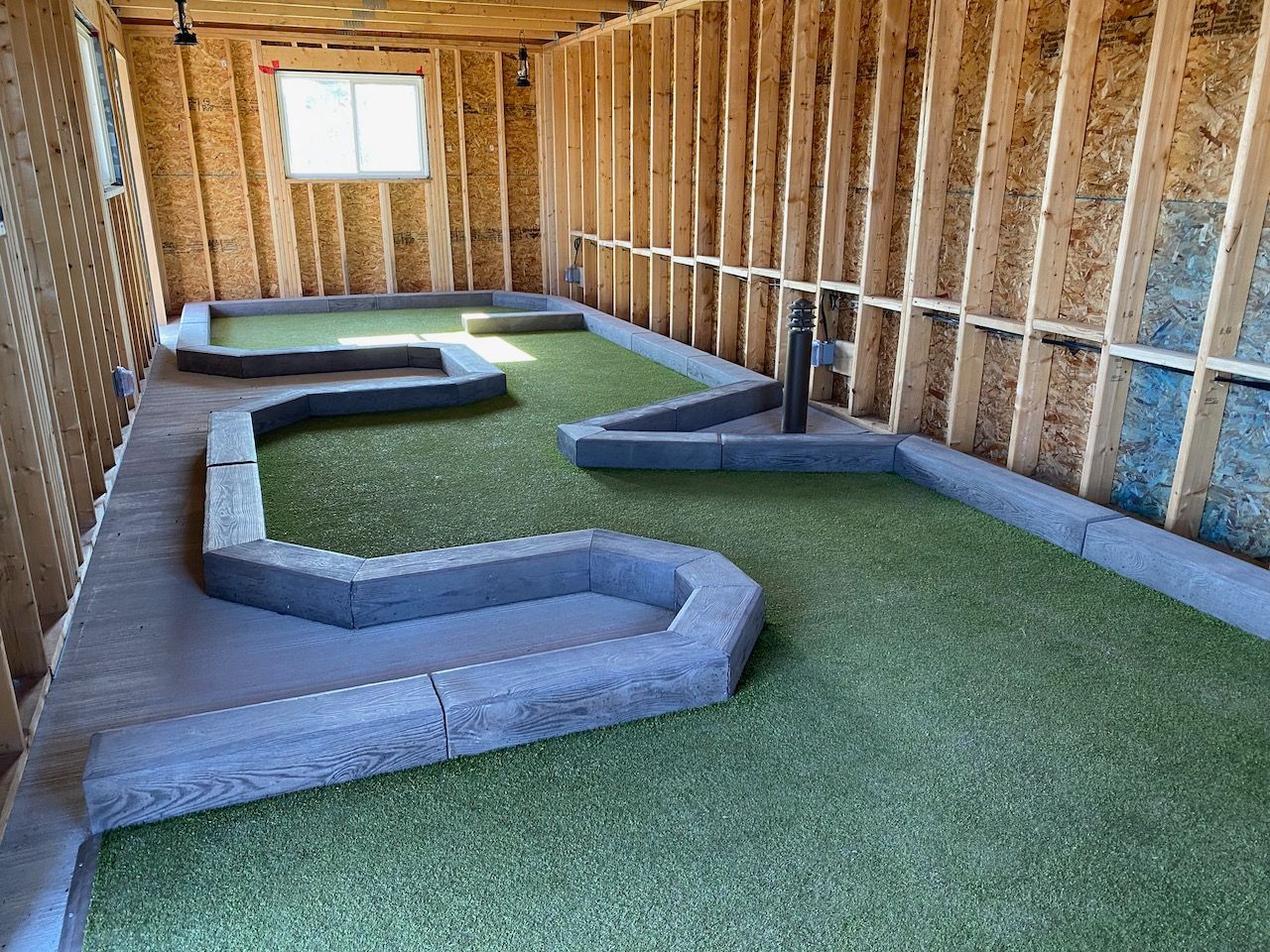 A small golf course is being built in a garage.