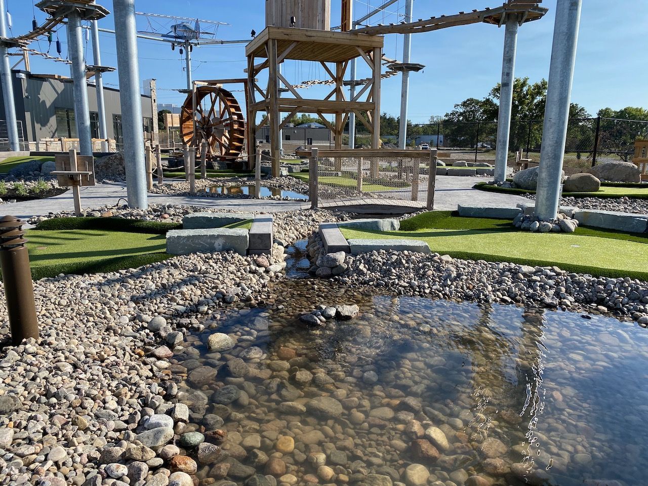 A pond filled with rocks and water in a park.