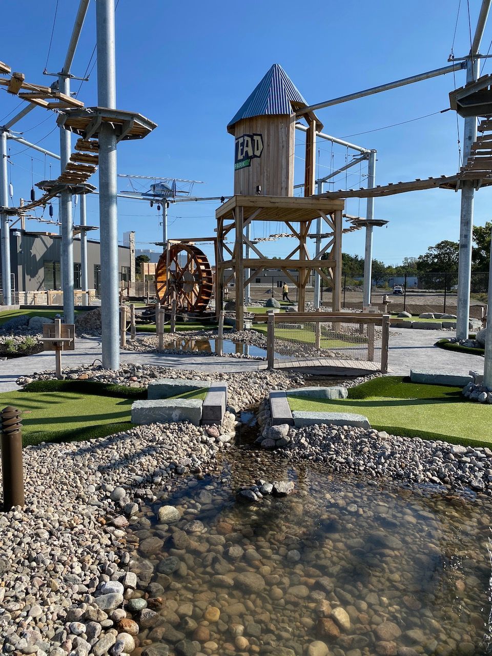 A ropes course with a water wheel in the background