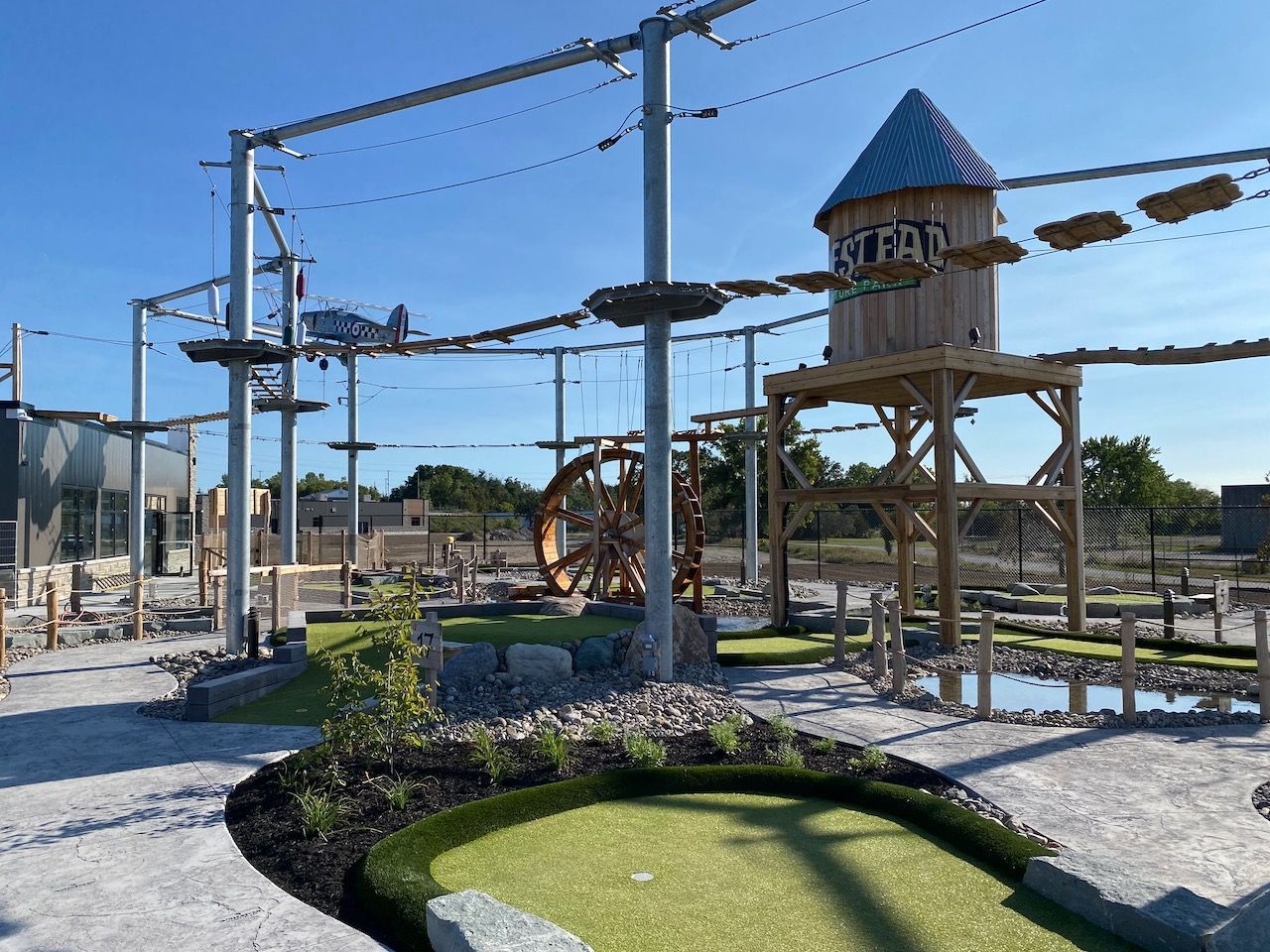 A mini golf course with a water tower in the background.