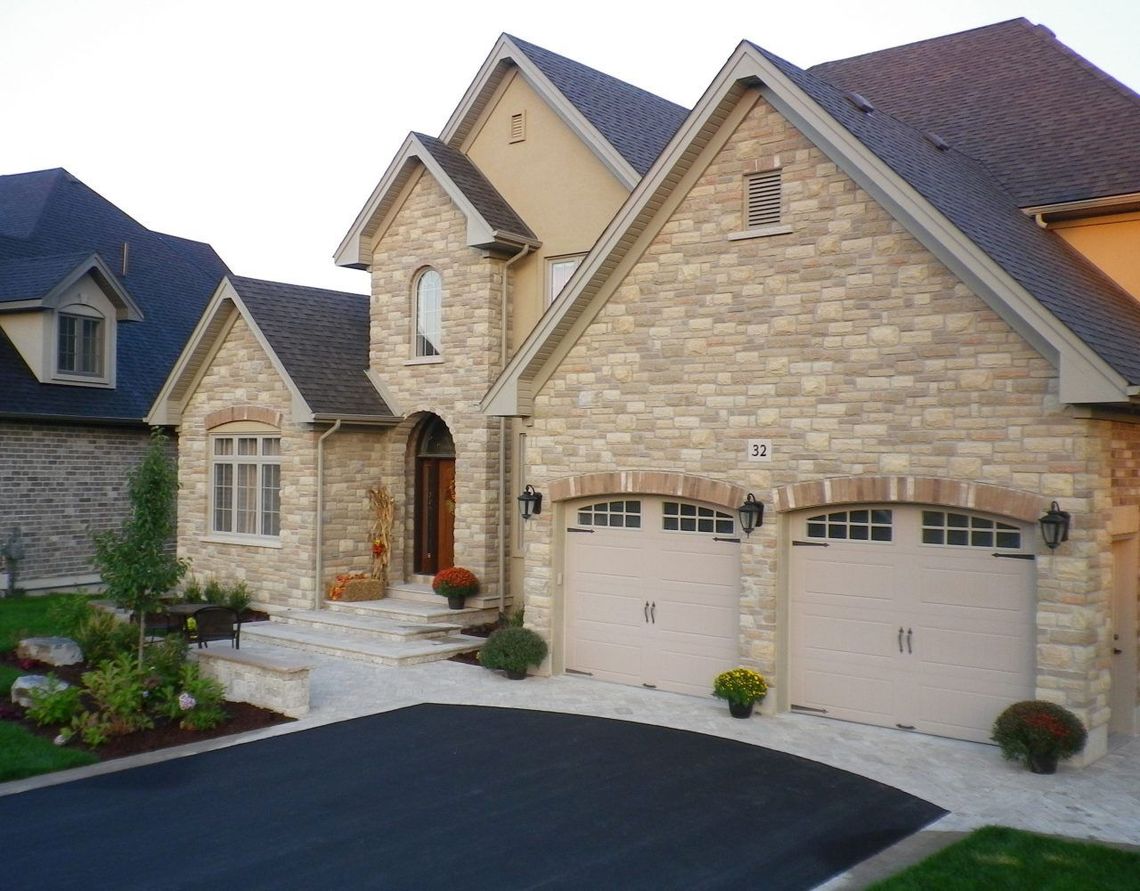 A large brick house with two white garage doors