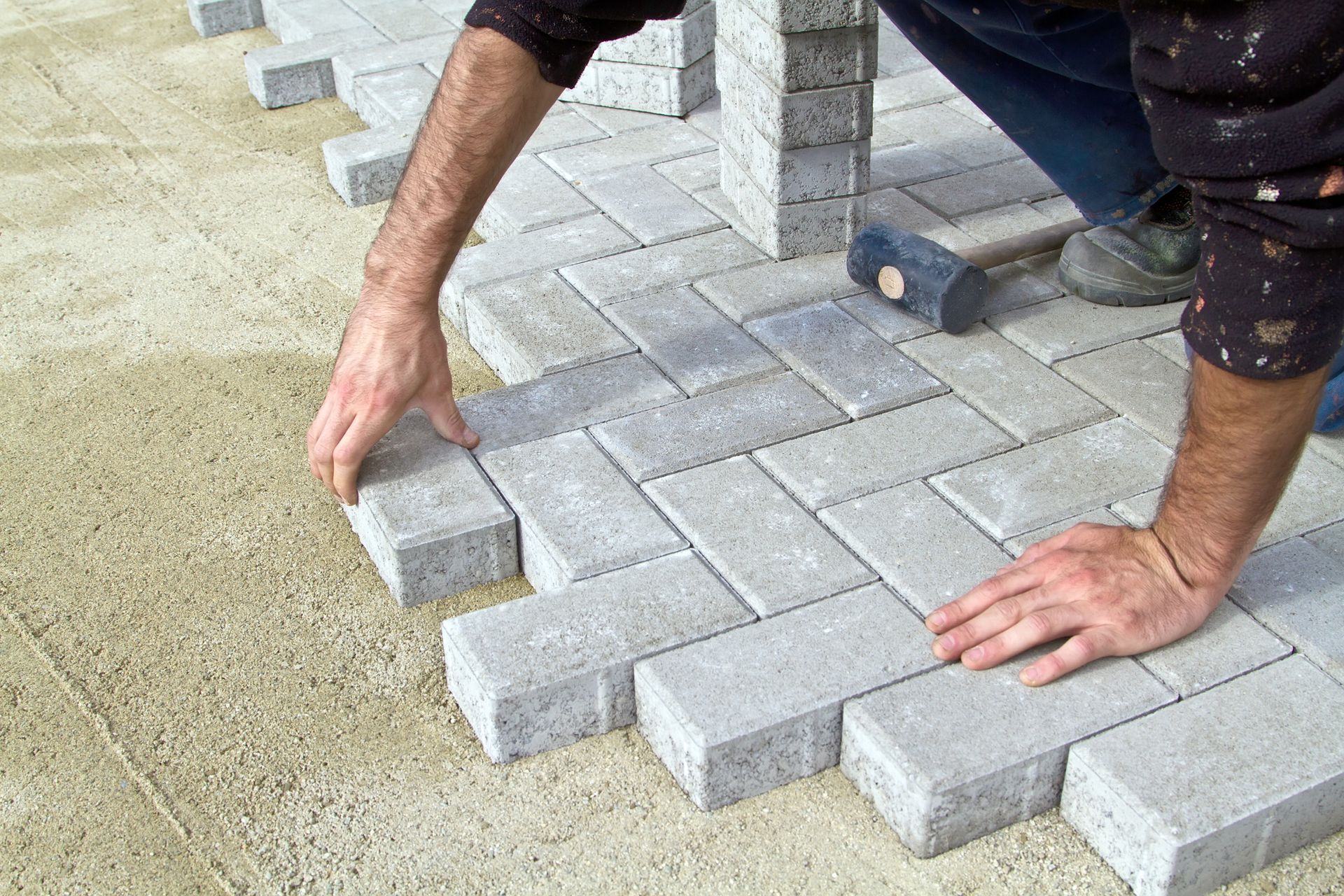 A man is laying bricks on the ground.