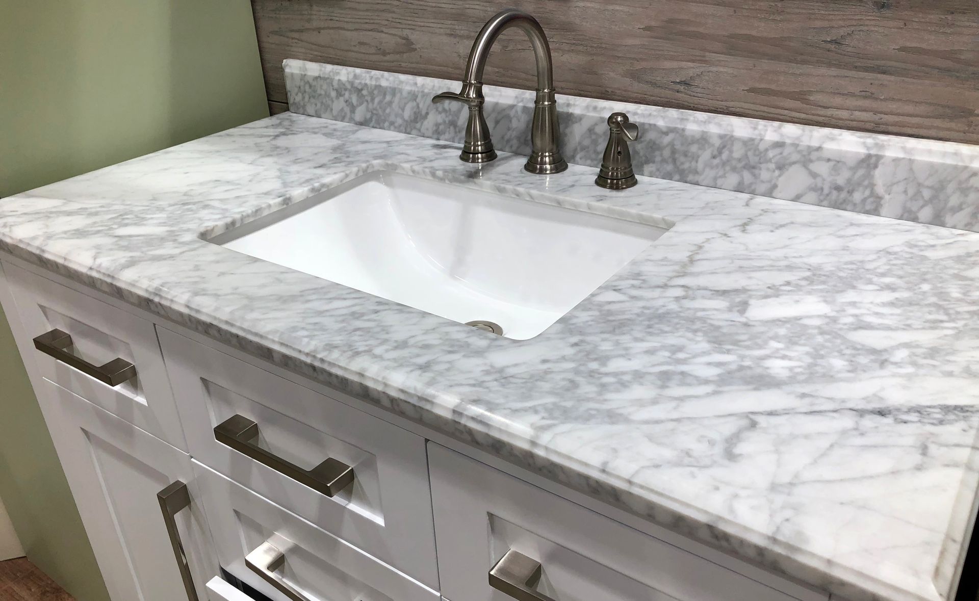A bathroom sink with a marble counter top and a faucet.