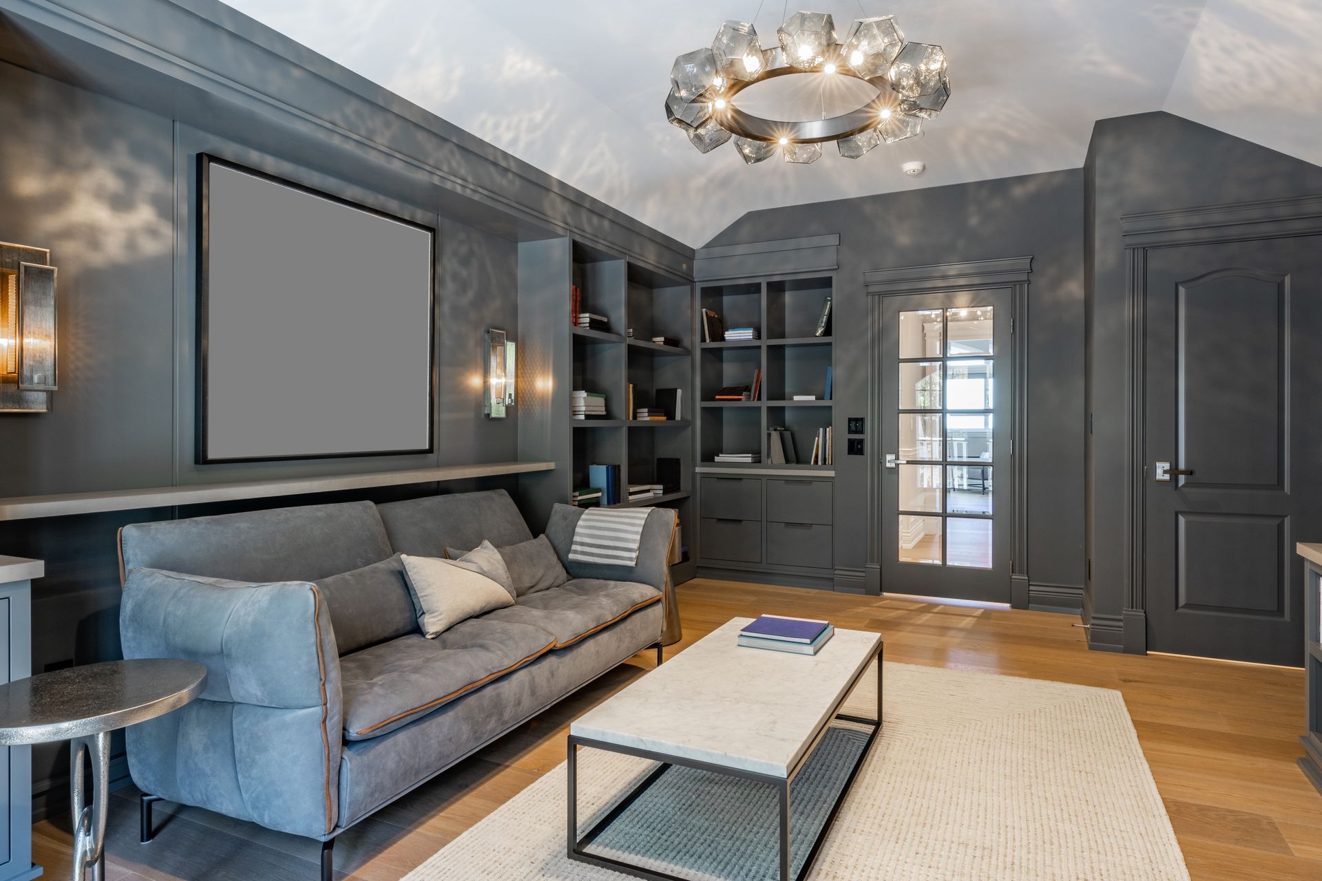A living room with a couch , coffee table , and a projector screen.