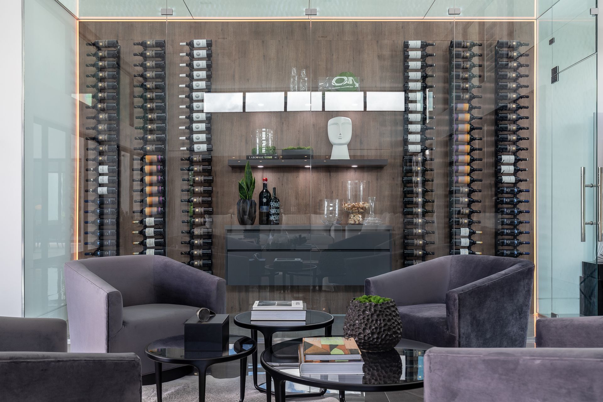 A living room with a lot of wine bottles on the wall.