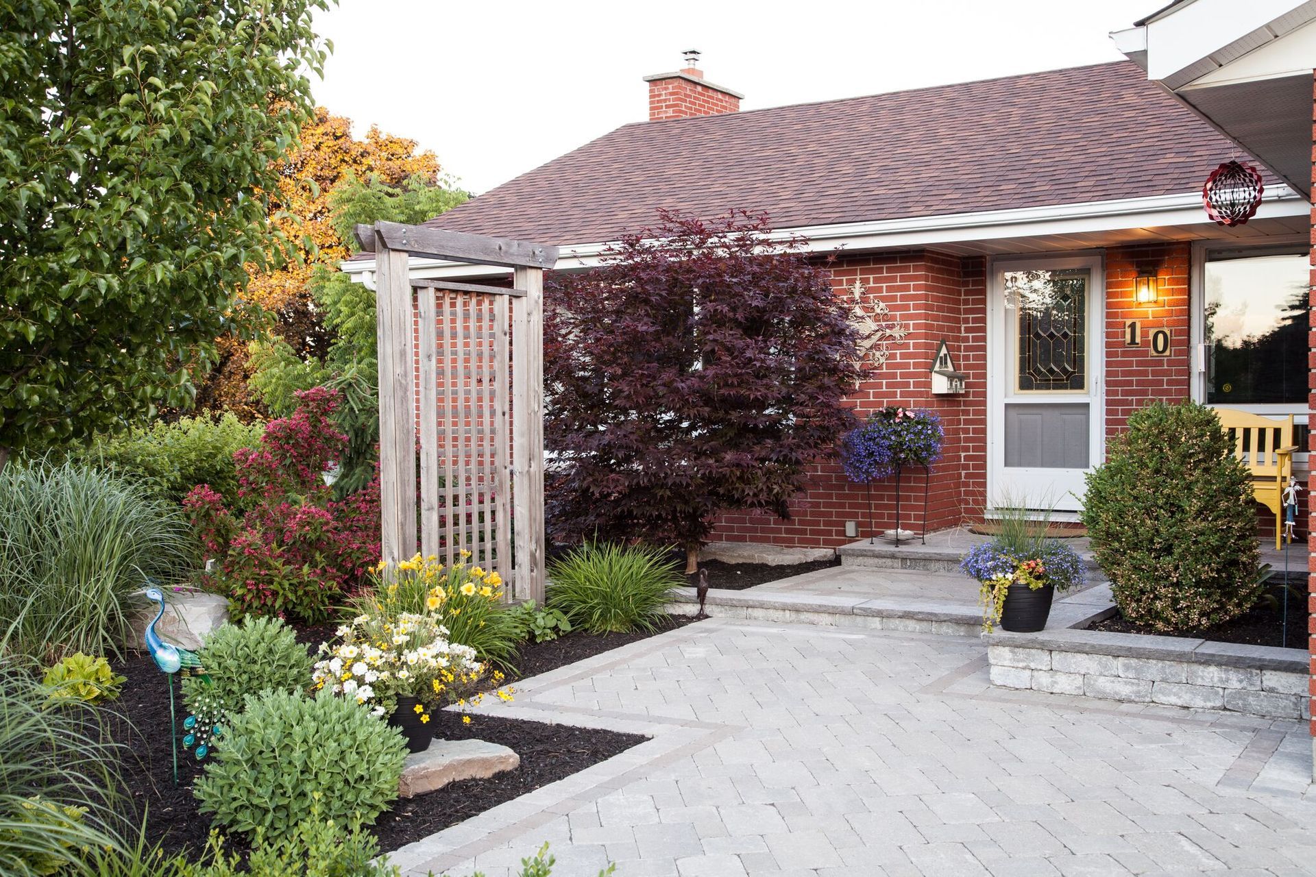 A brick house with a walkway leading to the front door