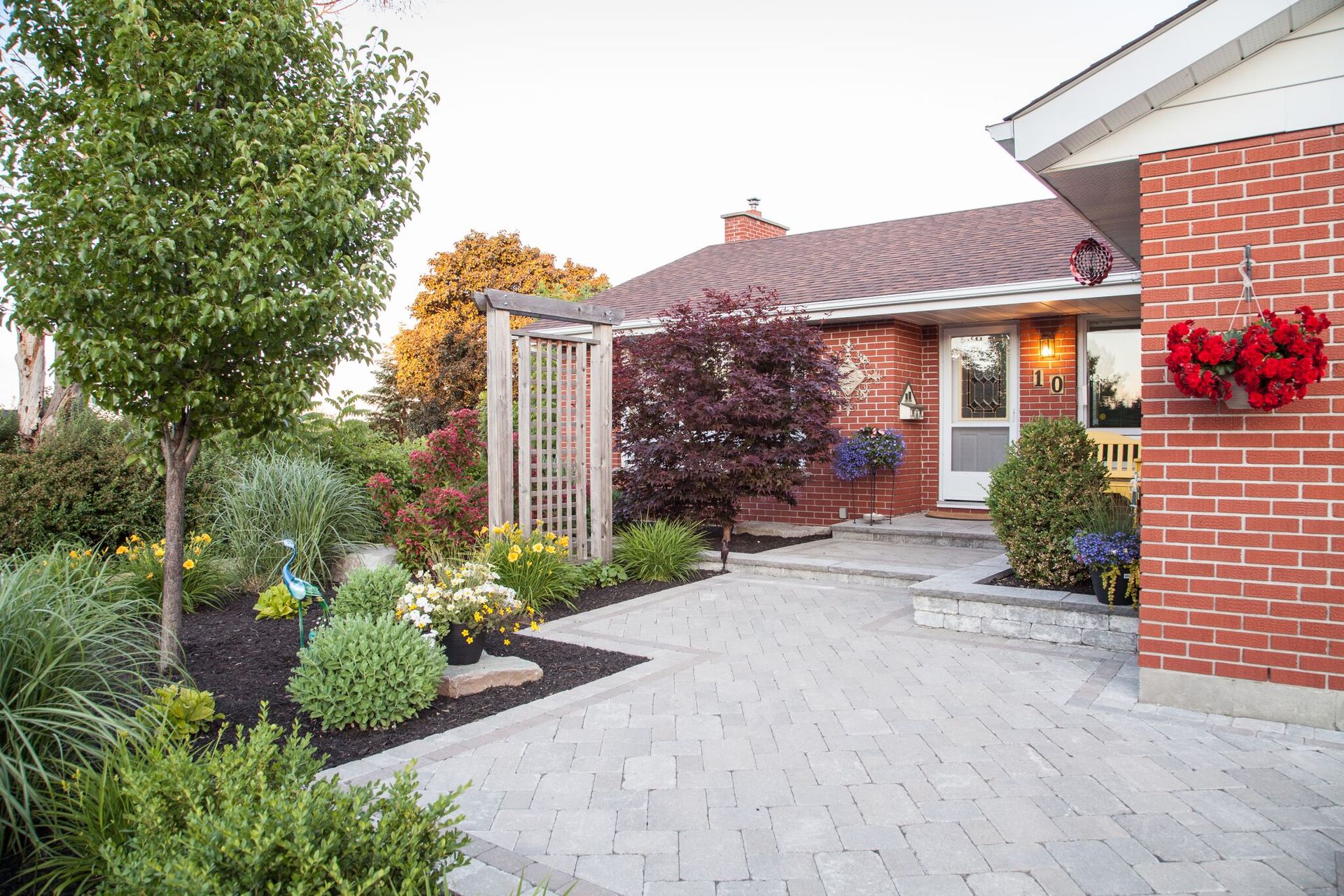 A brick house with a brick walkway leading to the front door.