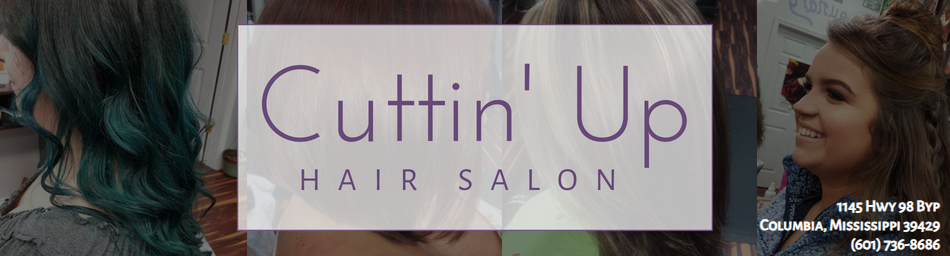 An HVAC gauge manifold set with red and blue knobs resting on a flat, gray industrial air conditioning unit.