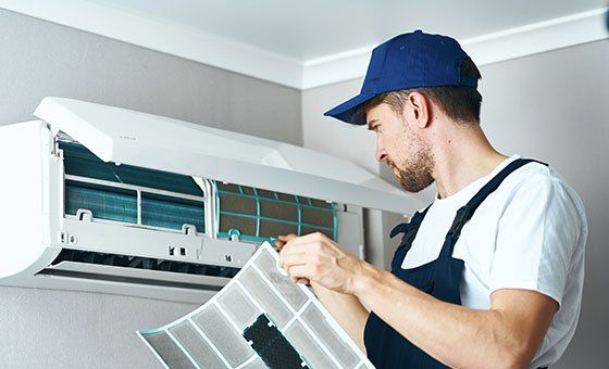 Man Clean and Repair the Air Conditioner — La Quinta, CA — Gibson Air Conditioning & Heating Inc