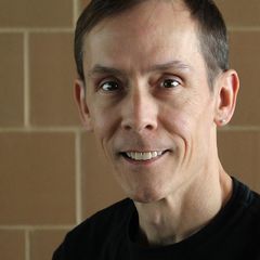 a man wearing a black shirt is smiling for the camera