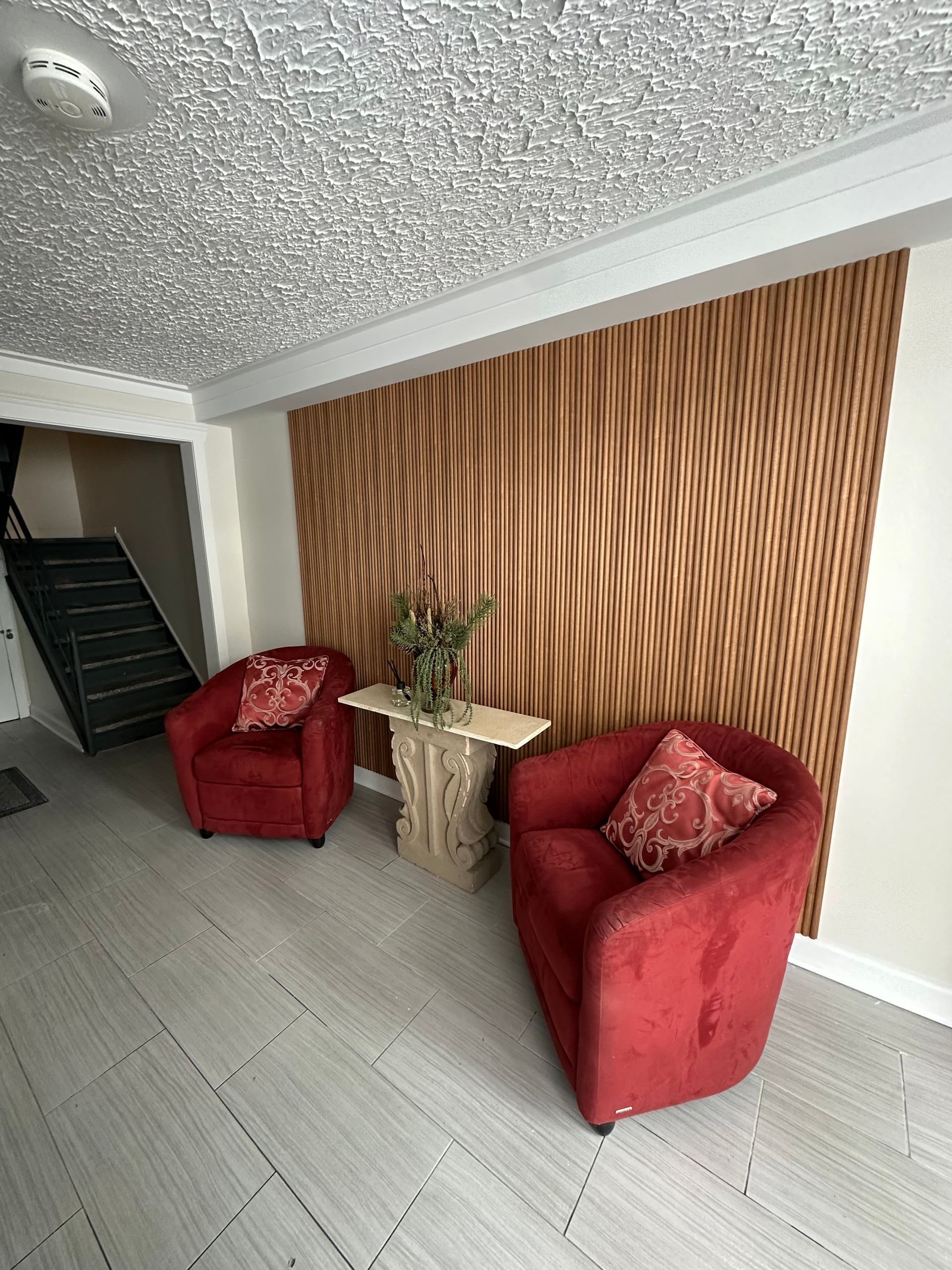 Un salon avec deux chaises rouges et une table.