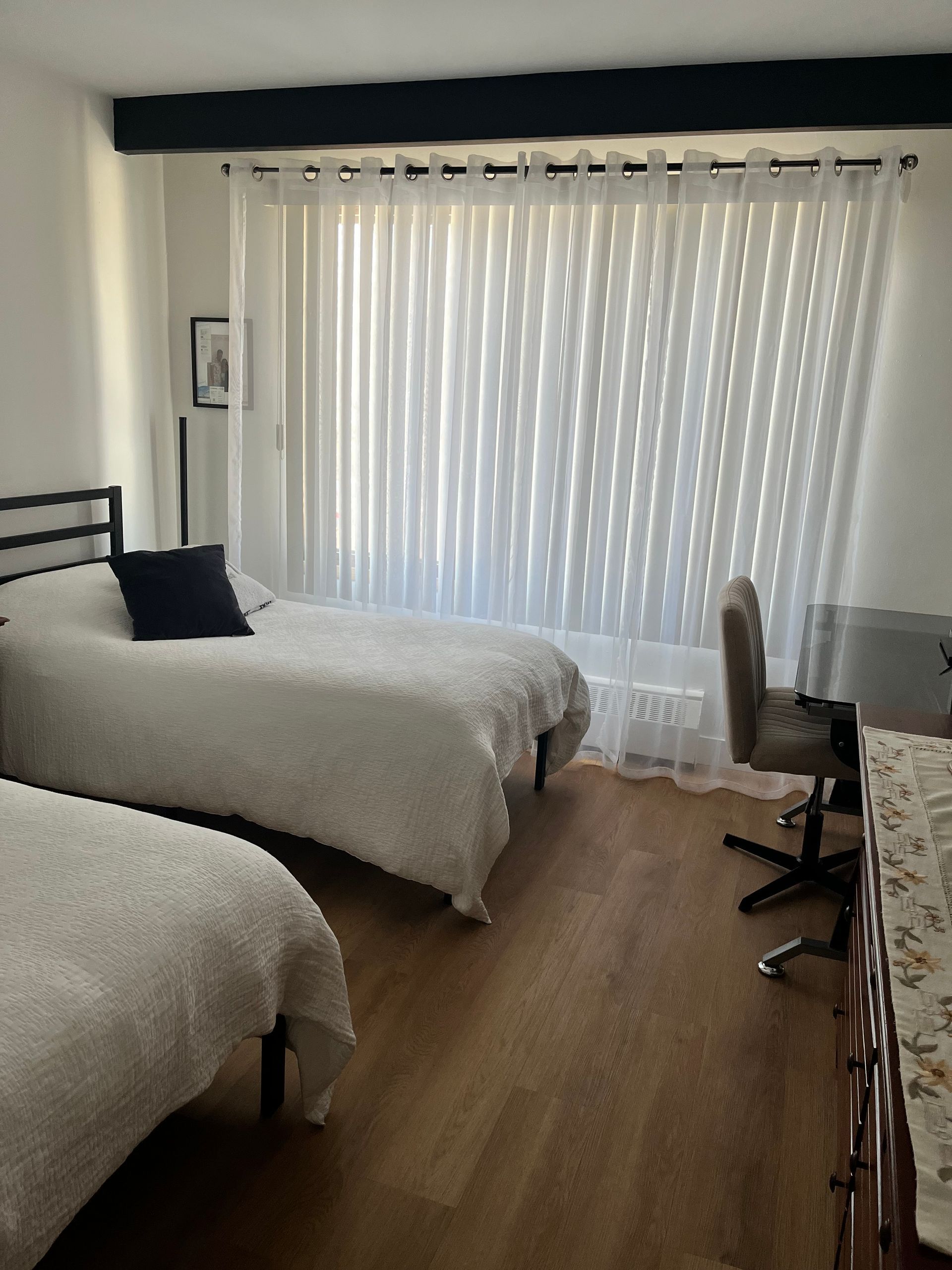 Une chambre avec deux lits et un bureau