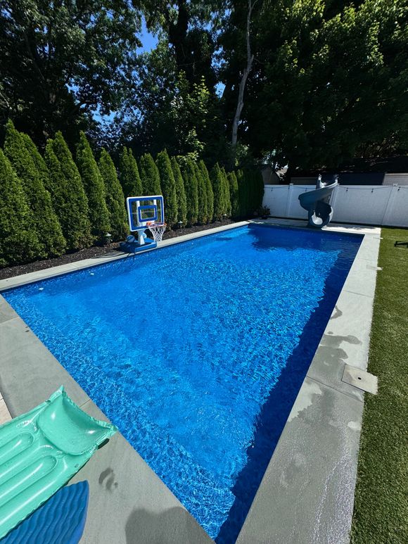 A woman 's legs are sticking out of a swimming pool.