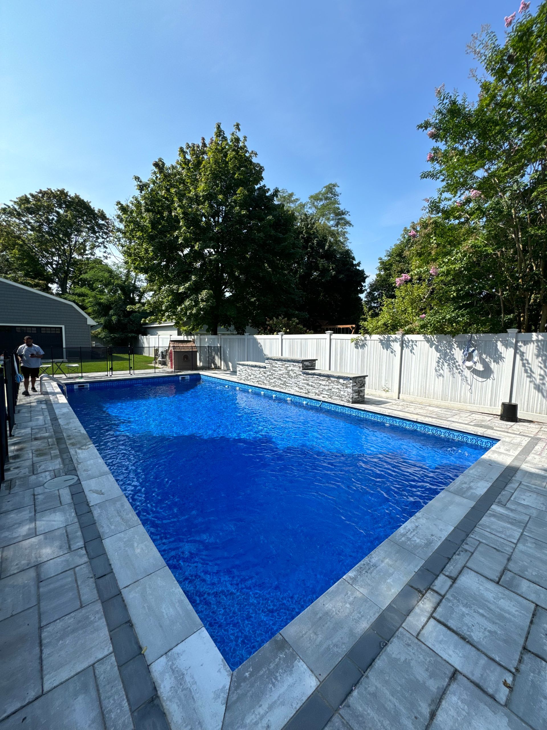 A woman 's legs are sticking out of a swimming pool.
