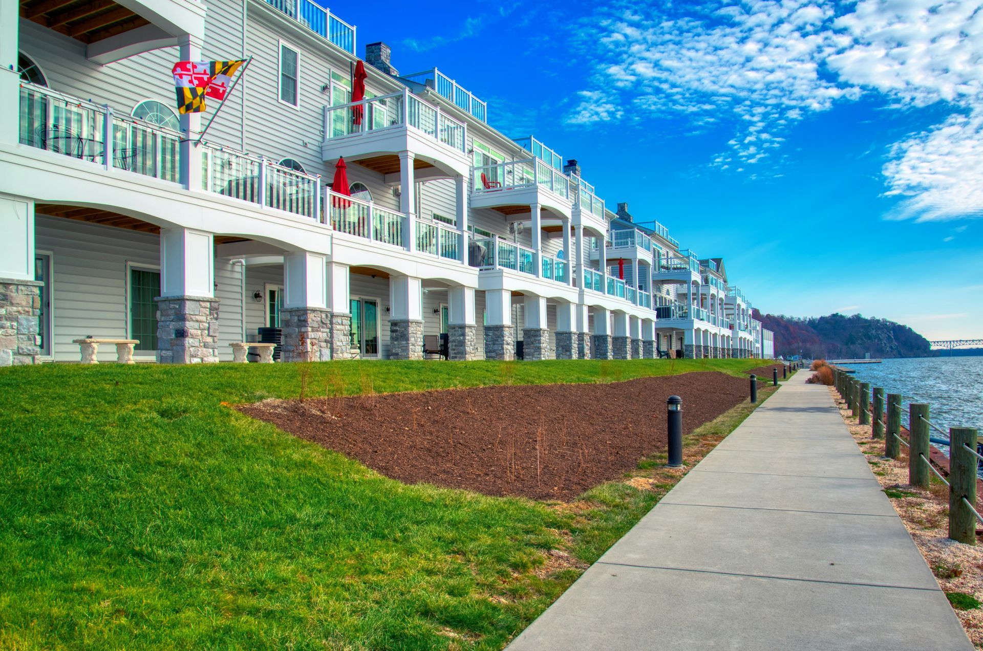 A group of people are walking down a path in front of a city skyline.