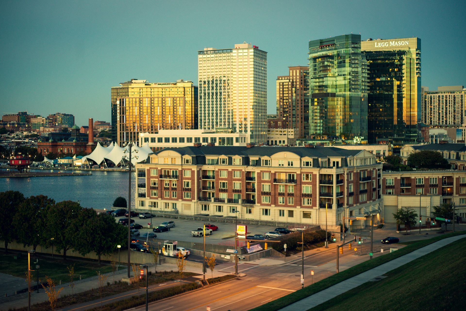 A group of people are walking down a path in front of a city skyline.