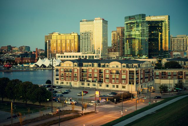 A group of people are walking down a path in front of a city skyline.