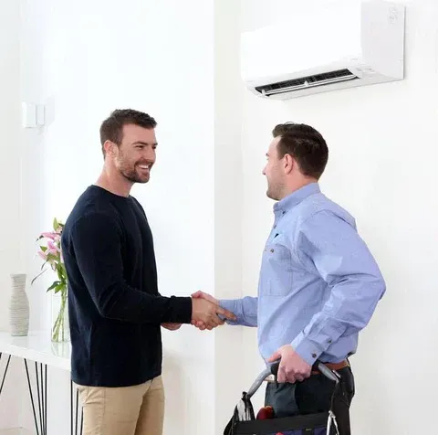 A White Air Conditioner is Hanging on a Wall — L & K Electrical & Air Conditioning in Scone, NSW