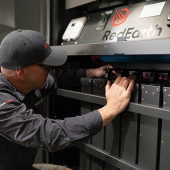 Man in cap working on a RedEarth battery system — L & K Electrical & Air Conditioning in Tamworth, NSW