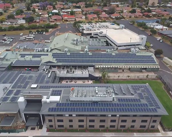 Aerial view of a Building with numerous solar panels on its roof in a suburban setting — L & K Electrical & Air Conditioning in Tamworth, NSW