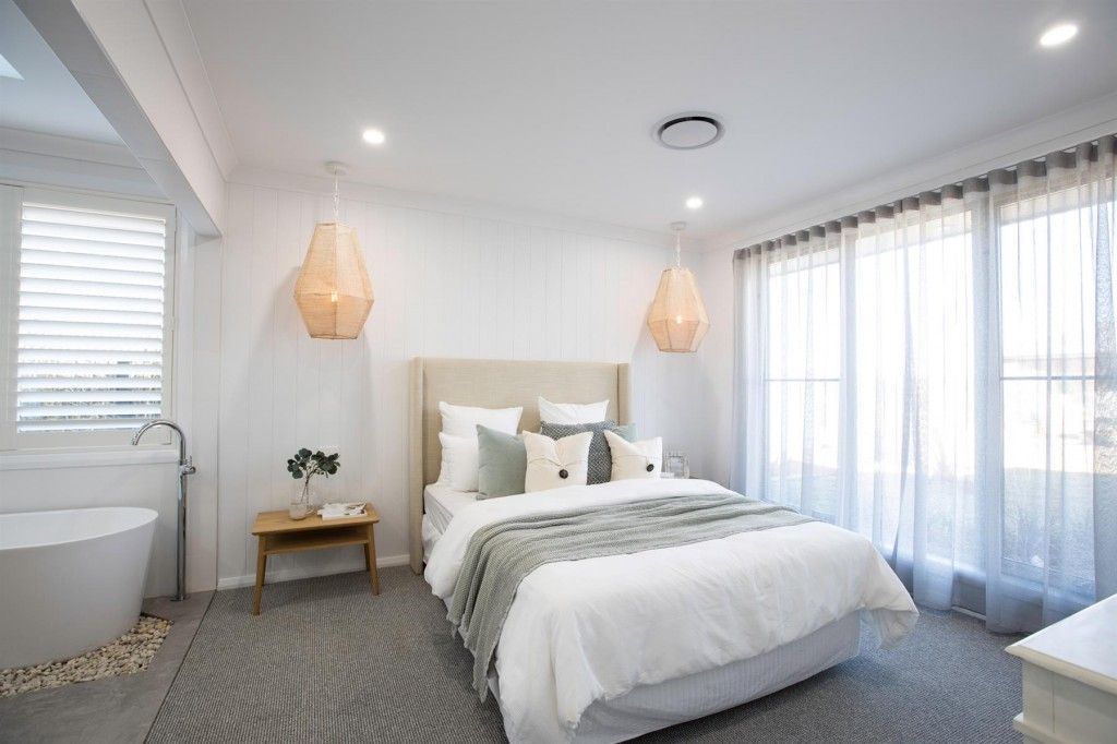Bedroom with white walls, bed, curtains, a freestanding tub, and two pendant lights — L & K Electrical & Air Conditioning in Uralla, NSW