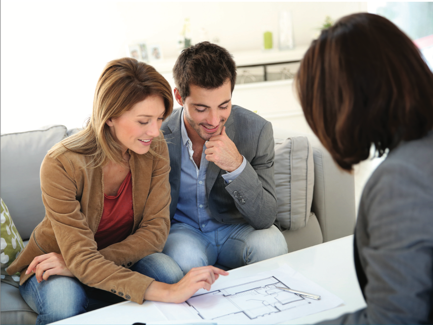 A lady sitting on a white couch below a Daikan air conditioner — L & K Electrical & Air Conditioning in Tamworth, NSW