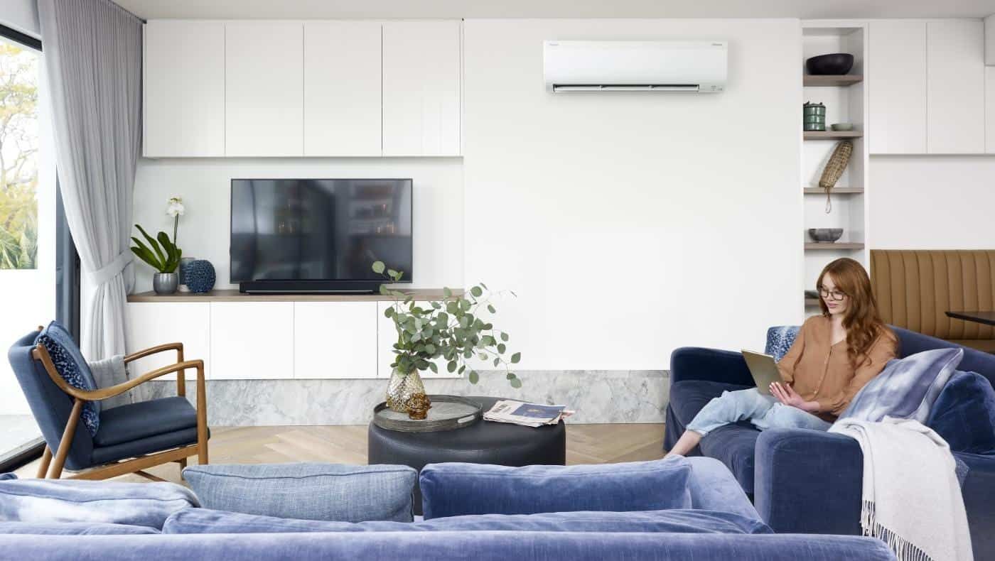A living room with a family and a Daikan air conditioner — L & K Electrical & Air Conditioning in Tamworth, NSW