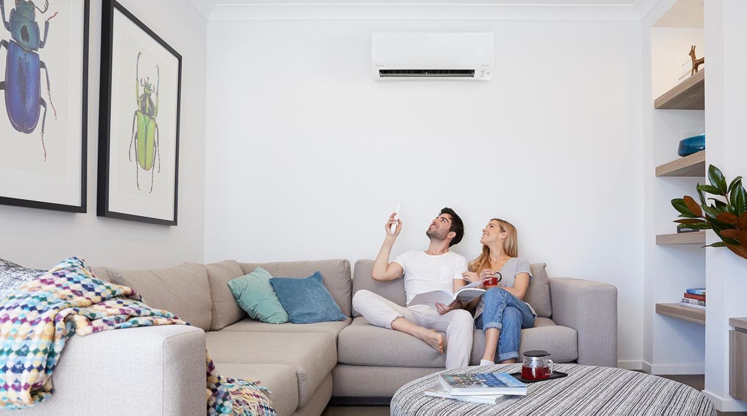 A White Air Conditioner is Hanging From the Ceiling Next to a Window — L & K Electrical & Air Conditioning in Tamworth, NSW