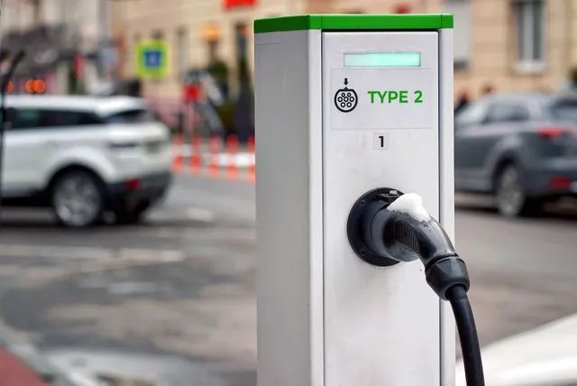 An Electric Car is Being Charged at a Charging Station on the Street — L & K Electrical & Air Conditioning in Tamworth, NSW