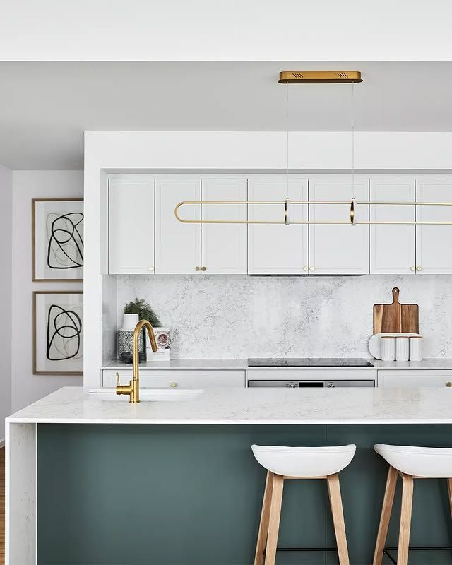 Modern kitchen with white cabinets, teal island, gold accents, and two white bar stools — L & K Electrical & Air Conditioning in Armidale, NSW