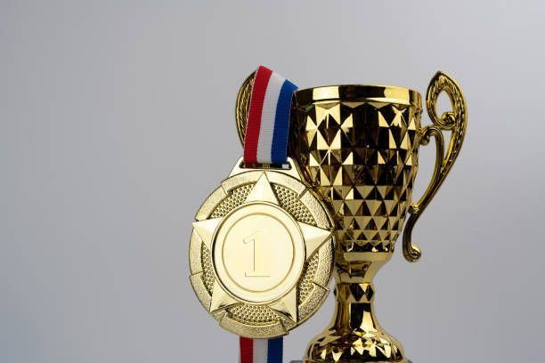 A gold trophy with a medal attached to it.