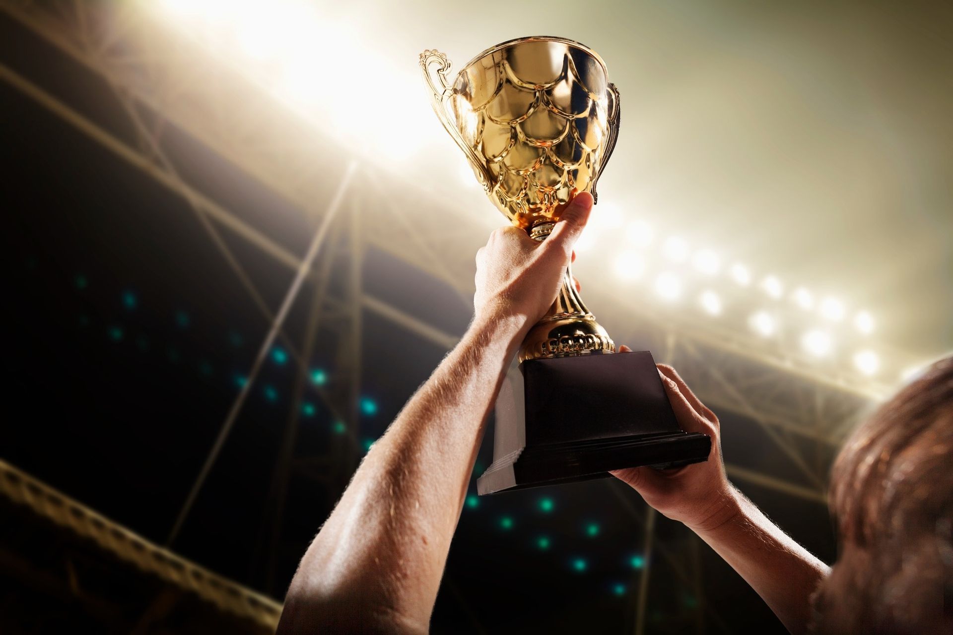 A person is holding a trophy in their hands in a stadium.