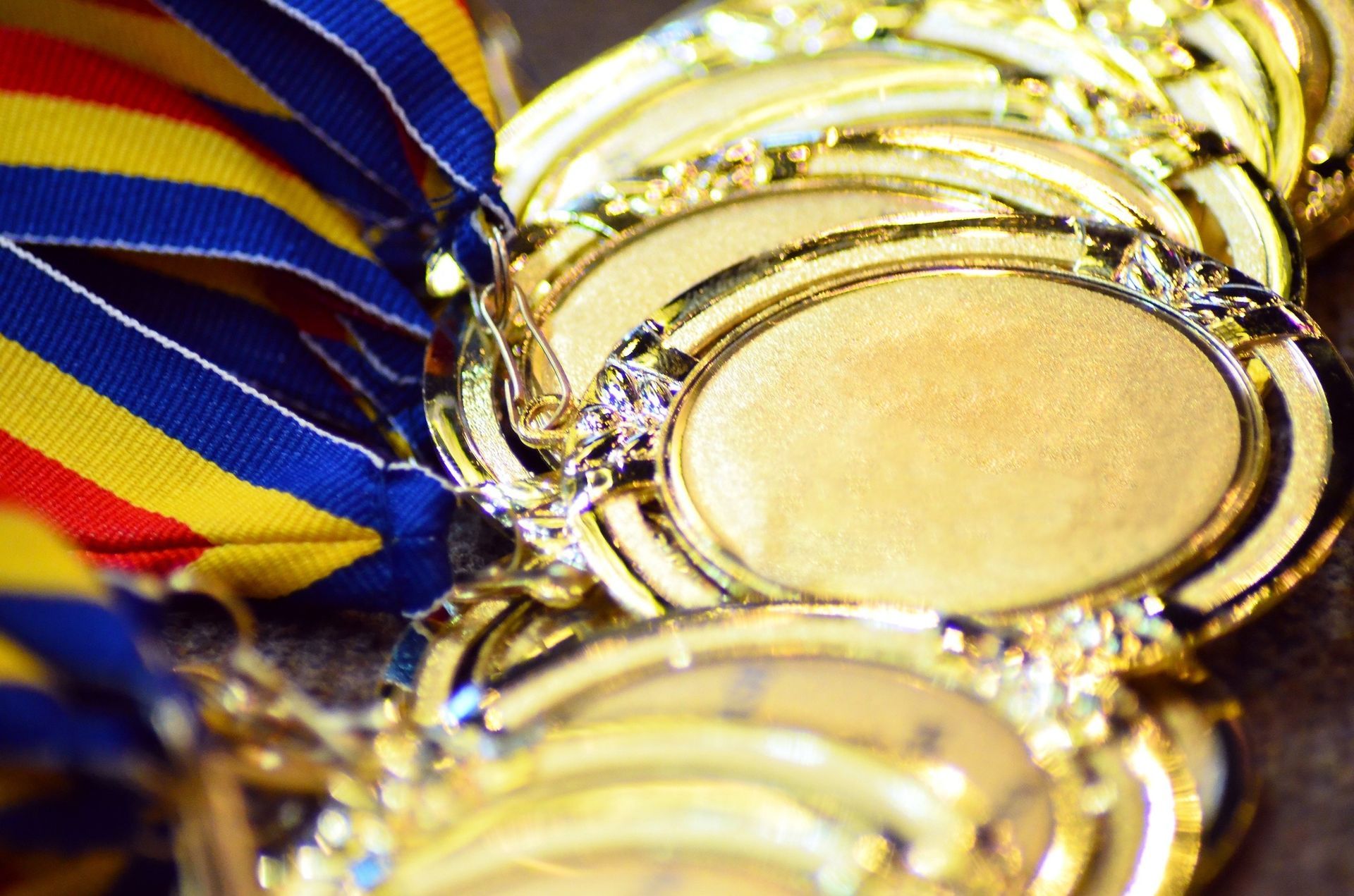 A bunch of gold medals are stacked on top of each other on a table.