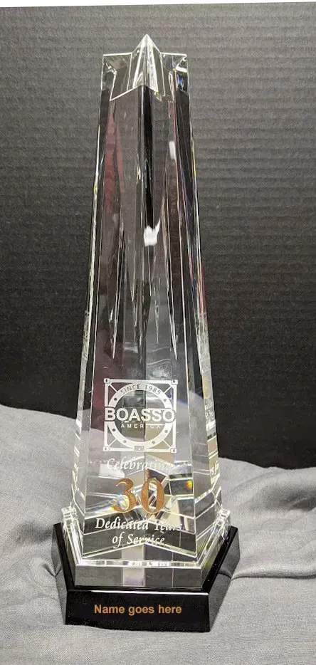 A clear glass trophy is sitting on a table.